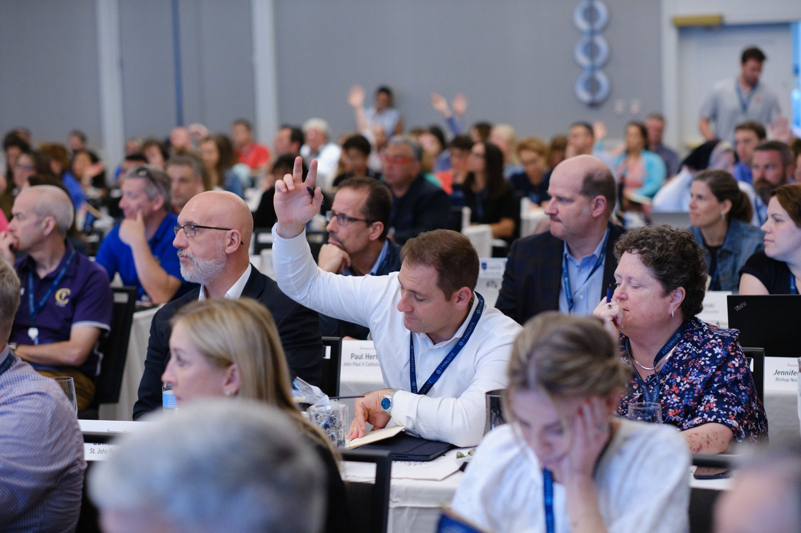Attendees in session raising their hands